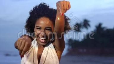 在沙滩上慢动作，一位超能力的美丽女子举着火花庆祝和跳跃